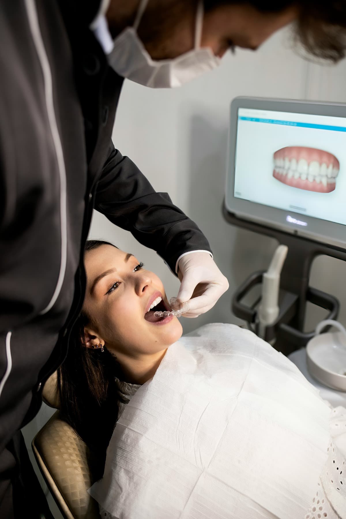 A dentist walking a patient through treatment in a modern operatory