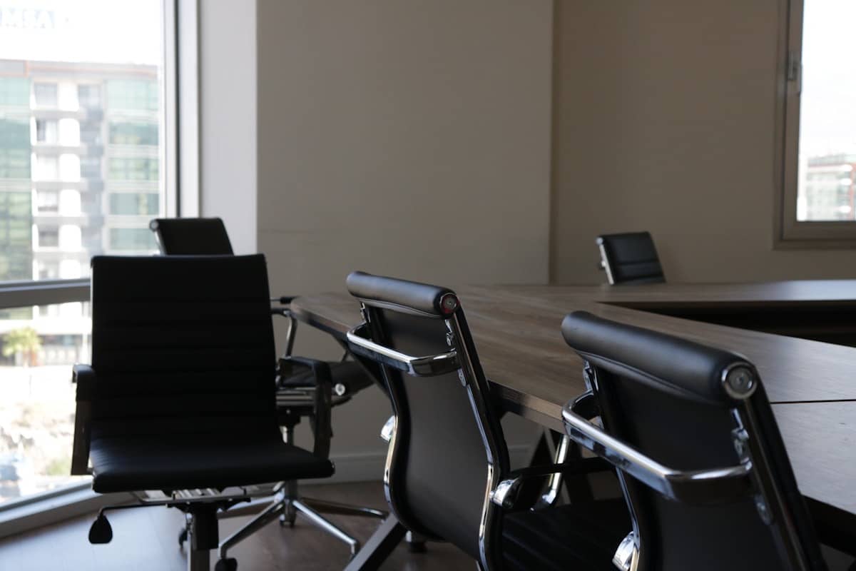 A row of empty office chairs around a desk